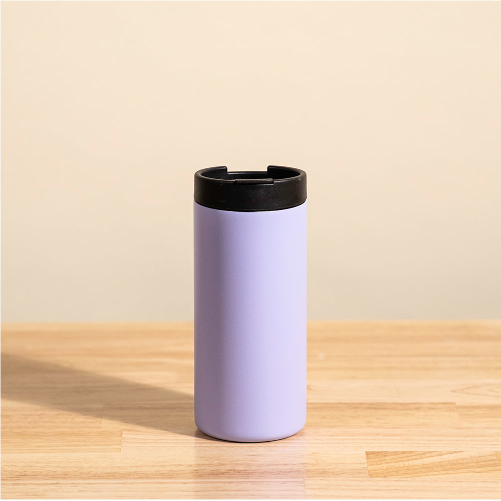 LAMOSE Grouse 12 oz insulated tumbler in pastel purple, standing upright on a wood table, showing its black lid and sleek design.