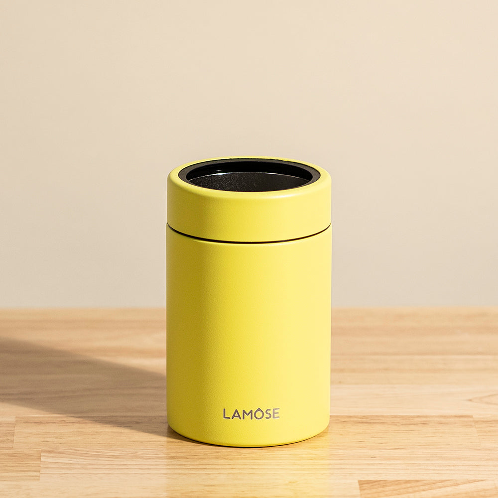 LAMOSE Logan 12 oz double-wall stainless steel yellow can cooler, front view on wood, with black rim and logo.