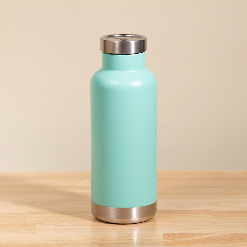 LAMOSE Moraine 20 oz insulated water bottle in turquoise, made of premium stainless steel, standing upright on a wooden surface.