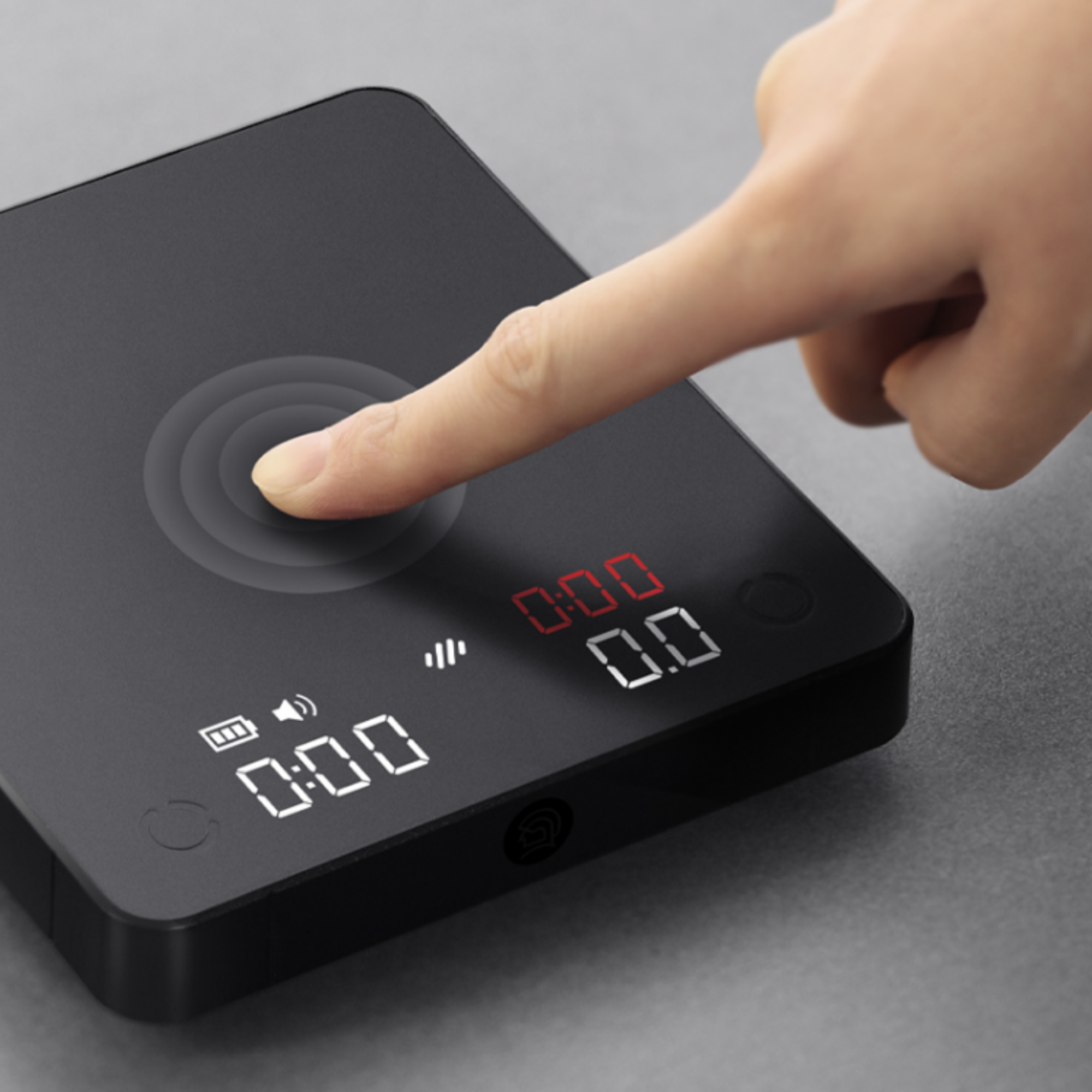 LAMOSE zeroHero Mini E-Smart Scale, matte black, shown close-up from above with a finger on its responsive touch control. Features dual LED display for precise weighing and timer functions.