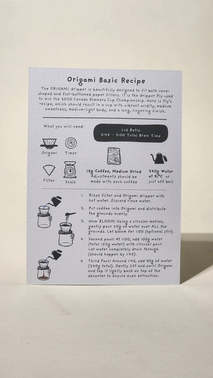 LAMOSE white Origami coffee brew guide recipe card on textured paper, flat lay. Features detailed steps, illustrations for tools & ingredients.