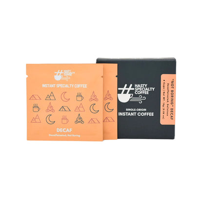 LAMOSE Hasty Specialty Coffee Decaf instant coffee box with orange sachets. Front view shows black box, orange packaging, and camping-themed icons.
