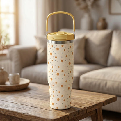 Close-up of LAMOSE Cascade 40 oz tumbler featuring cream body with orange flowers and blue hearts pattern, topped with a yellow lid.