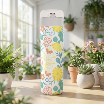 White 16oz travel tumbler featuring yellow, peach, and turquoise floral pattern with gray rim accent standing in natural light.