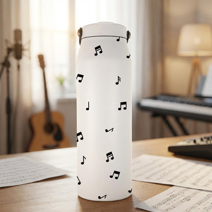 Grouse 34 oz insulated white tumbler featuring a pattern of black musical notes and symbols sitting on a piano bench.