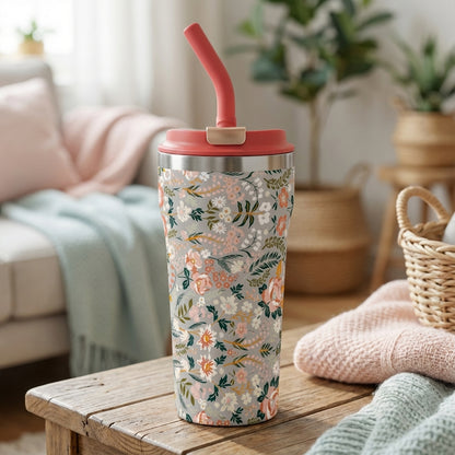 LAMOSE Bow 16 oz tumbler featuring a grey background with peach and pink floral pattern, silver rim, and coral straw standing on a sunlit wooden surface.