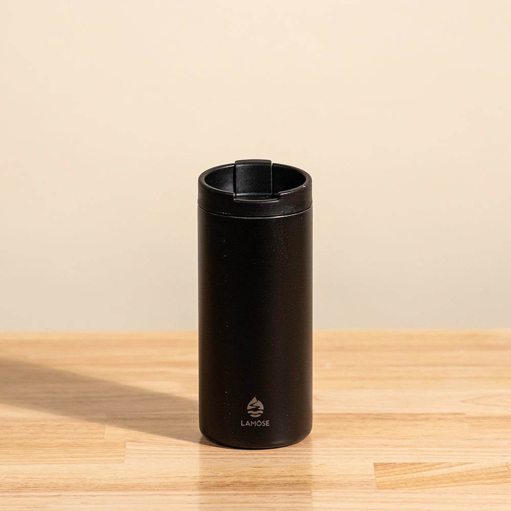 LAMOSE Grouse 12 oz insulated tumbler in onyx black, made from durable stainless steel, shown from a front angle on a wooden surface.