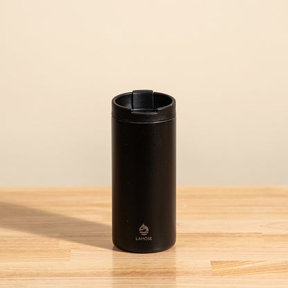 LAMOSE Grouse 12 oz insulated tumbler in onyx black, made from durable stainless steel, shown from a front angle on a wooden surface.