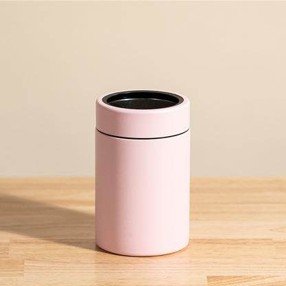 LAMOSE Logan 12 oz stainless steel can cooler in baby pink, matte finish with black inner rim, standing upright on wood.