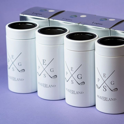 Four white Logan 16 oz insulated stainless steel tumblers with golf logos and black lids, showcasing LAMOSE quality on a purple surface.