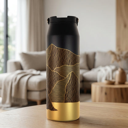 LAMOSE Grouse 34 oz insulated tumbler featuring a matte black top transitioning into abstract golden mountain lines and a shiny gold base