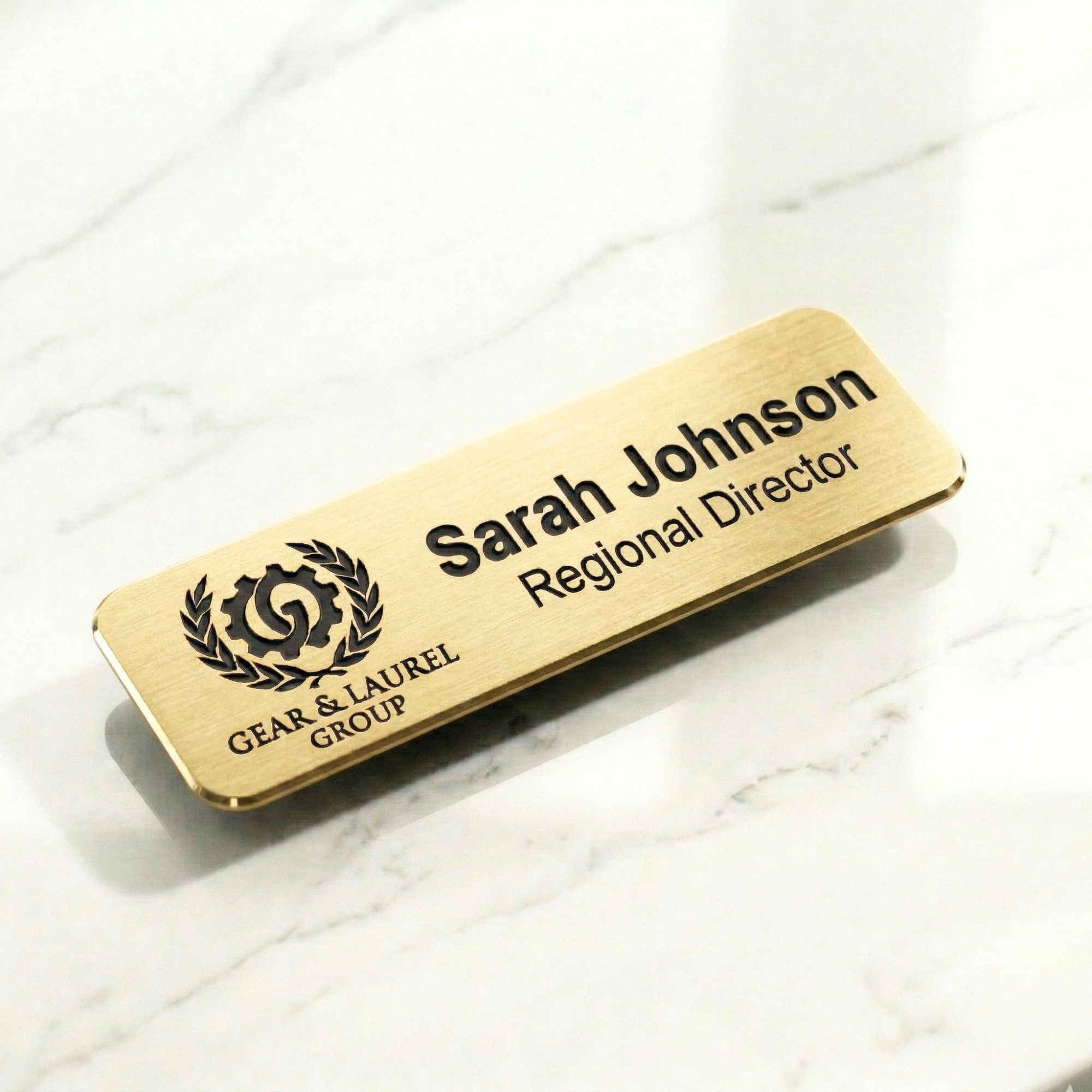 Custom engraved name tag badge in gold finish with magnetic backing for professional identification and workplace use