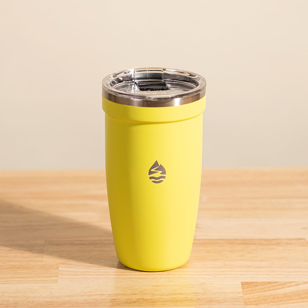 LAMOSE Peyto 16 oz yellow insulated stainless steel tumbler with clear lid and brand logo on a wooden surface, front view.