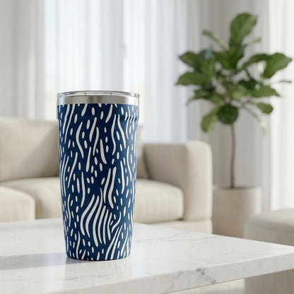 Navy blue Peyto 16oz tumbler with white abstract lines pattern sitting on a white marble table in a sunlit modern living room.