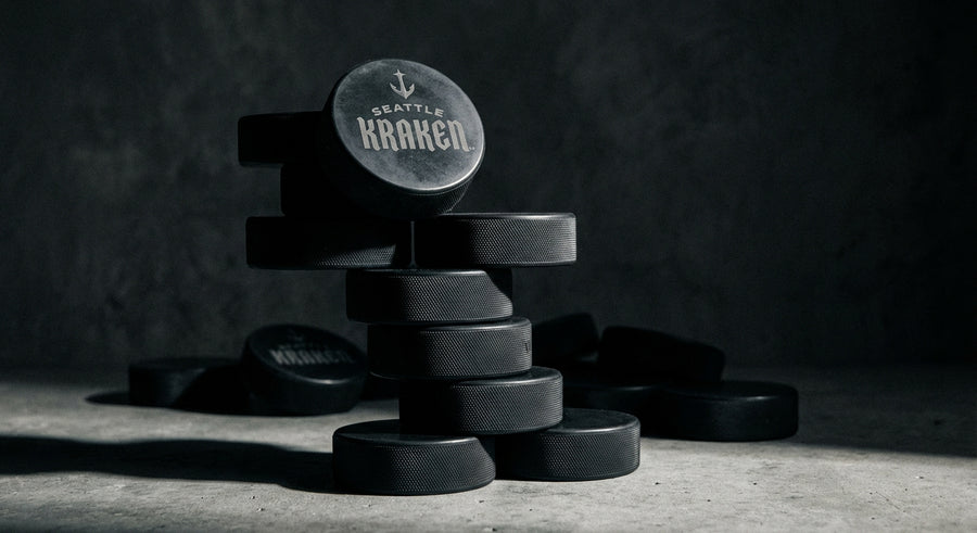 Stack of 10 laser engraved hockey pucks dramatic studio side lighting