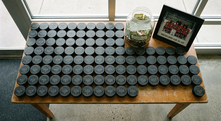 Overhead flat lay fundraiser pucks with donation jar and team photo