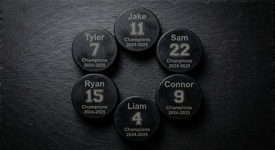 Overhead flat lay 6 laser engraved hockey pucks Champions 2024-2025 circle arrangement
