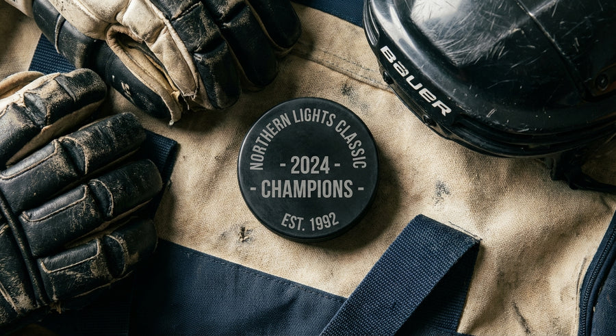 Laser engraved tournament puck on hockey equipment bag with gloves