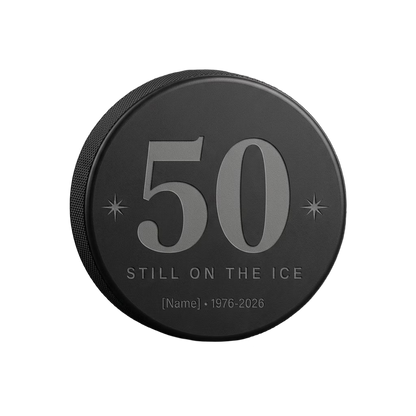 "50 Still on the Ice" Hockey Birthday Engraved Puck — laser-engraved hockey puck, tonal black-on-black engraving on vulcanized rubber, made in Calgary