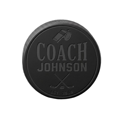 "Coach [Name] Est." Engraved Hockey Puck — laser-engraved hockey puck, tonal black-on-black engraving on vulcanized rubber, made in Calgary