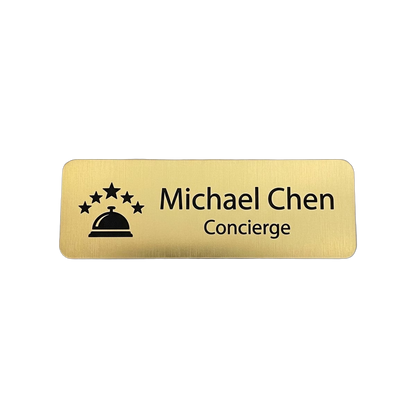 Hotel & Hospitality Name Tag — Concierge / Front Desk / Guest Services — LAMOSE custom laser-engraved professional name tag, Trotec Trolase two-layer acrylic laminate (1.5 × 3 in.) in Brushed Gold with Black engraving, made in Calgary, Canada since 2017.