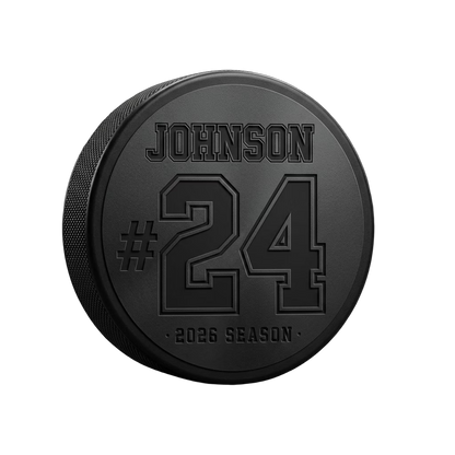 Player Name + Jersey Number Engraved Hockey Puck — laser-engraved hockey puck, tonal black-on-black engraving on vulcanized rubber, made in Calgary