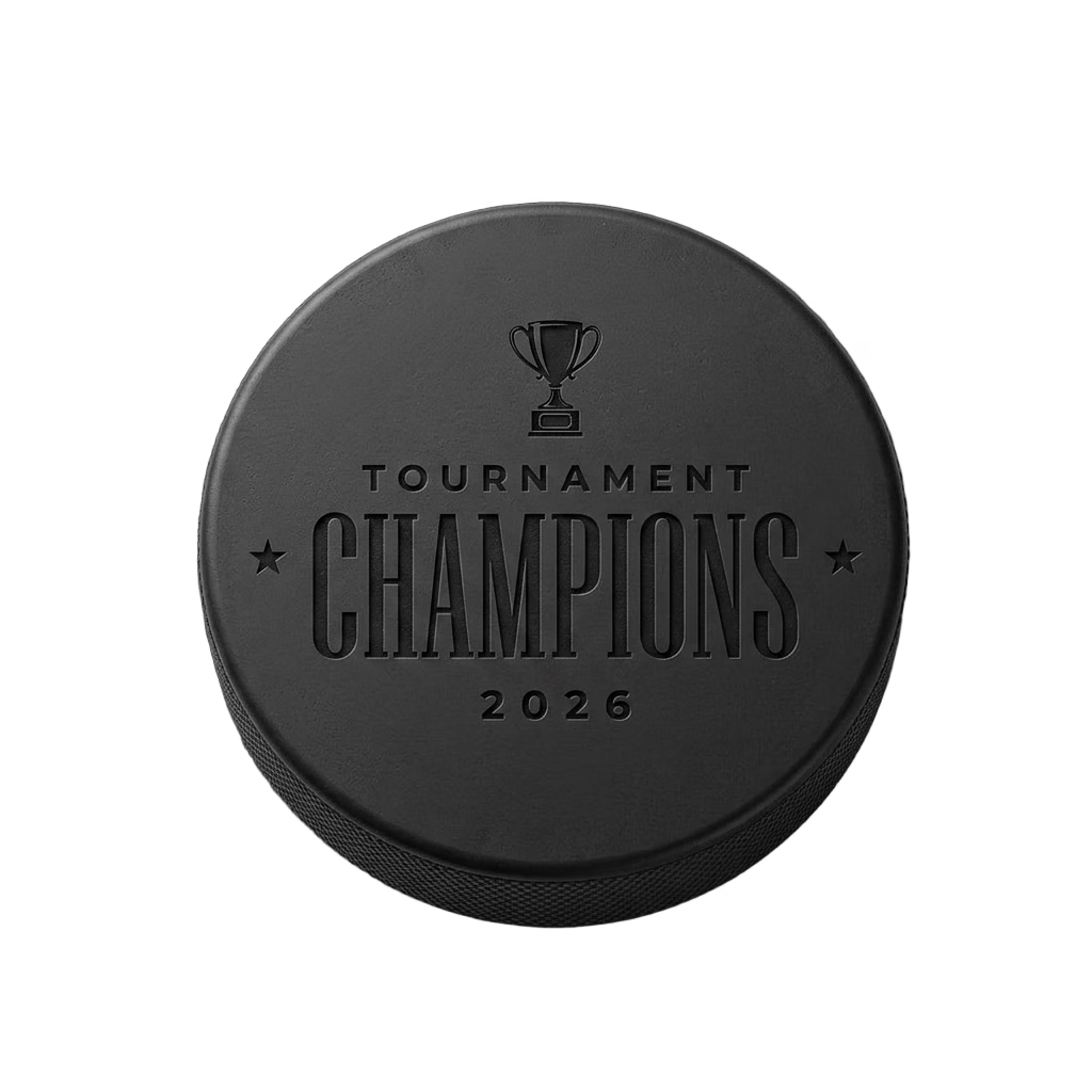 "Tournament Champions 2026" Engraved Hockey Puck — laser-engraved hockey puck, tonal black-on-black engraving on vulcanized rubber, made in Calgary