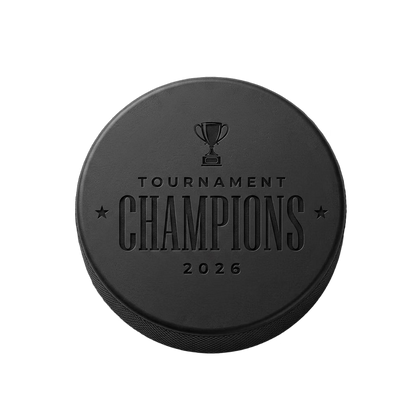 "Tournament Champions 2026" Engraved Hockey Puck — laser-engraved hockey puck, tonal black-on-black engraving on vulcanized rubber, made in Calgary