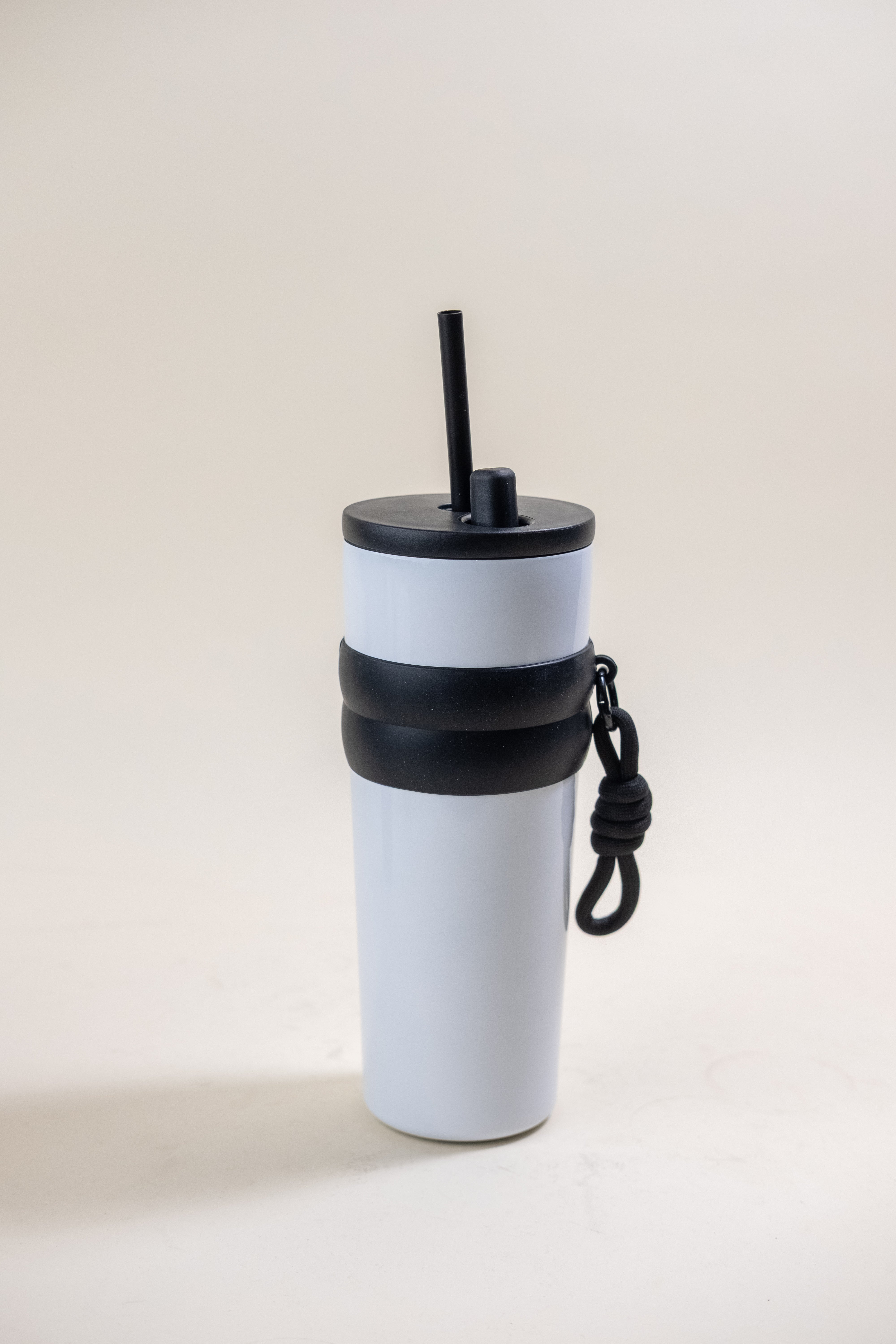 Standalone image white stainless steel straw tumbler with rubber grip bands and a BPA-free plastic straw, showcasing its sleek design and functionality for everyday use. 