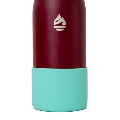 LAMOSE light teal silicone base protector on a textured burgundy bottle, showcasing the iconic mountain-water logo.